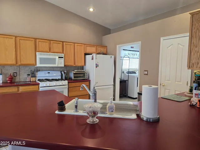 a kitchen with stainless steel appliances granite countertop sink table and chairs