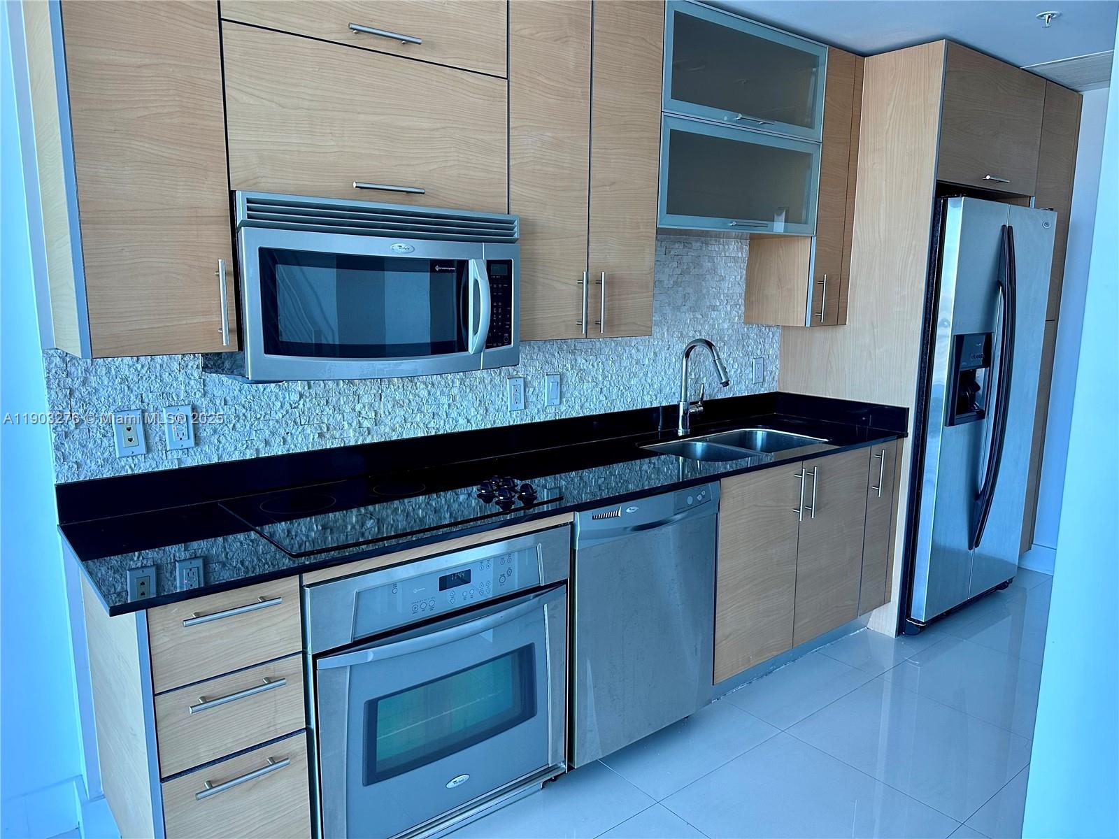 60 Southwest 13th Street, Unit 2213 Miami, FL 33130 - Photo 4 of 19 a kitchen with granite countertop cabinets and sink