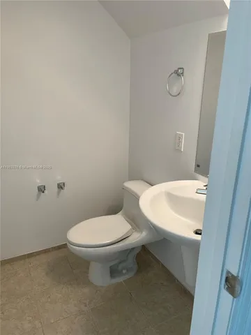 a white toilet sitting next to a white sink