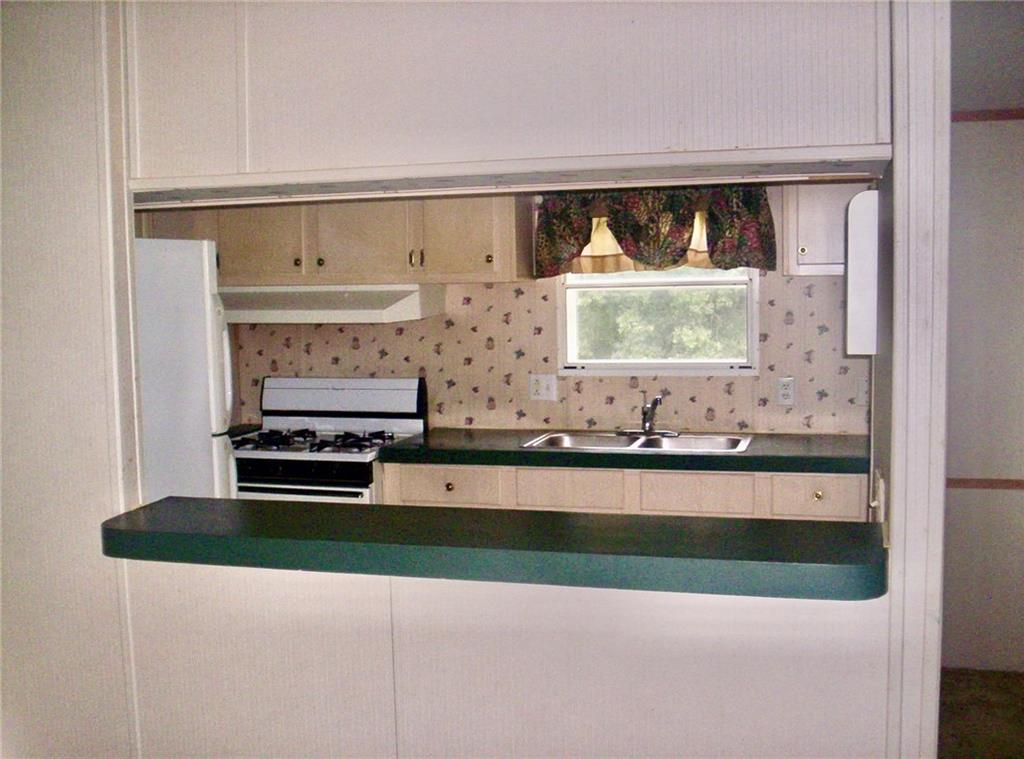 112 Cemetery Street Kingston, GA 30145 - Photo 25 of 28 a kitchen with a stove a sink and a window