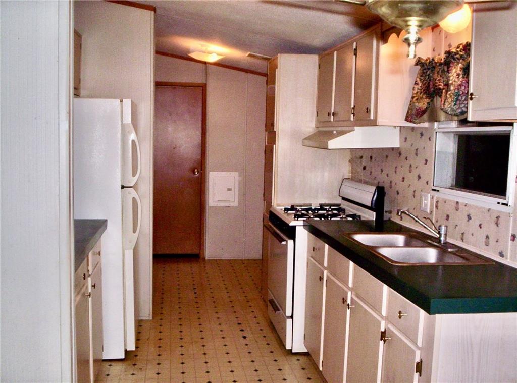 112 Cemetery Street Kingston, GA 30145 - Photo 26 of 28 a kitchen with stainless steel appliances granite countertop a sink stove and refrigerator