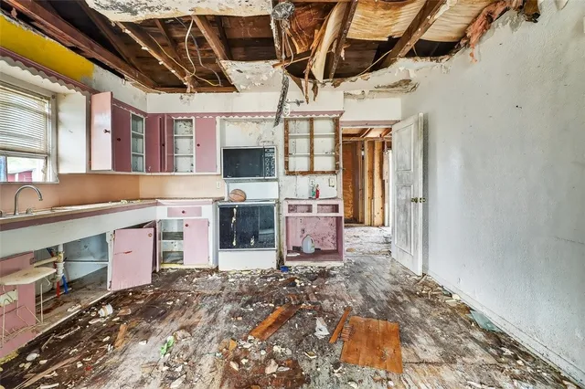 a room with stainless steel appliances kitchen island granite countertop a stove and a sink