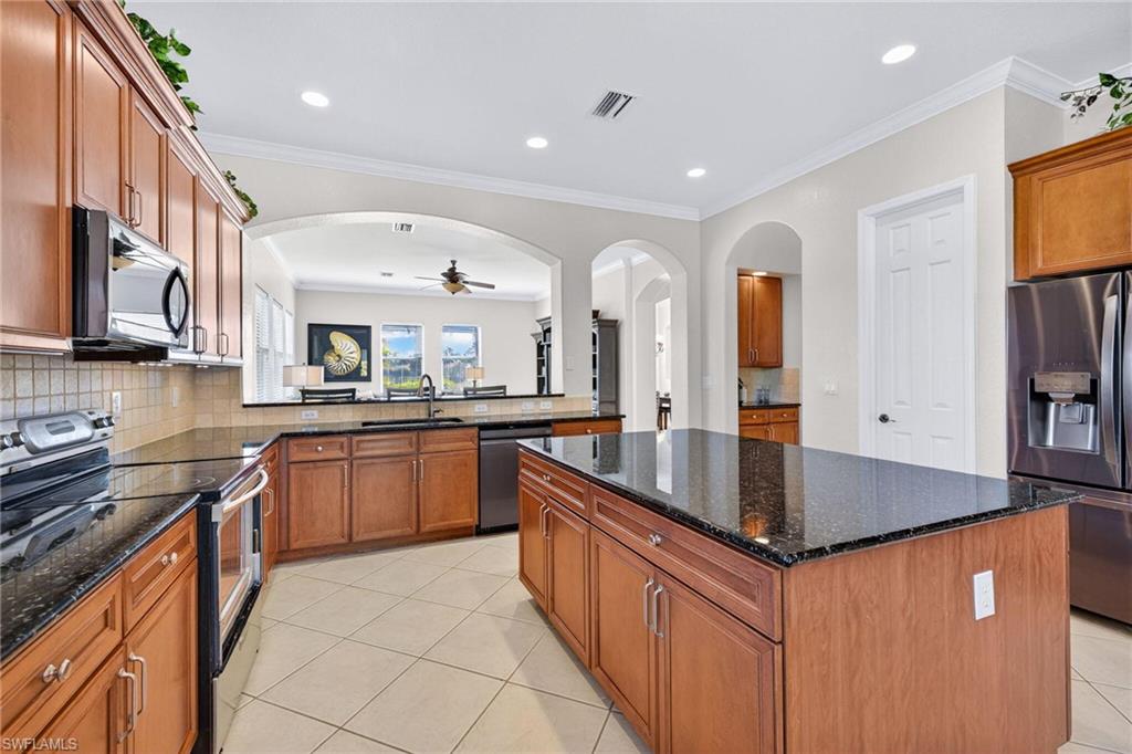 2212 Vardin Place Naples, FL 34120 - Photo 11 of 50 a large kitchen with stainless steel appliances granite countertop a lot of counter space and a sink
