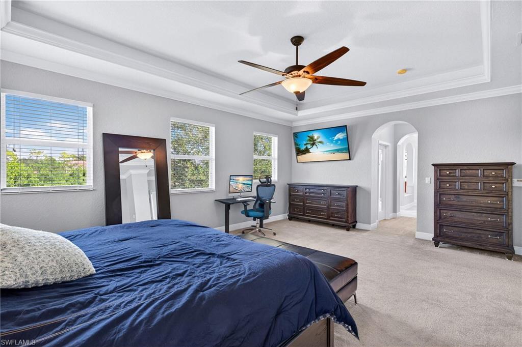 2212 Vardin Place Naples, FL 34120 - Photo 16 of 50 a bedroom with a bed a dresser and a large window