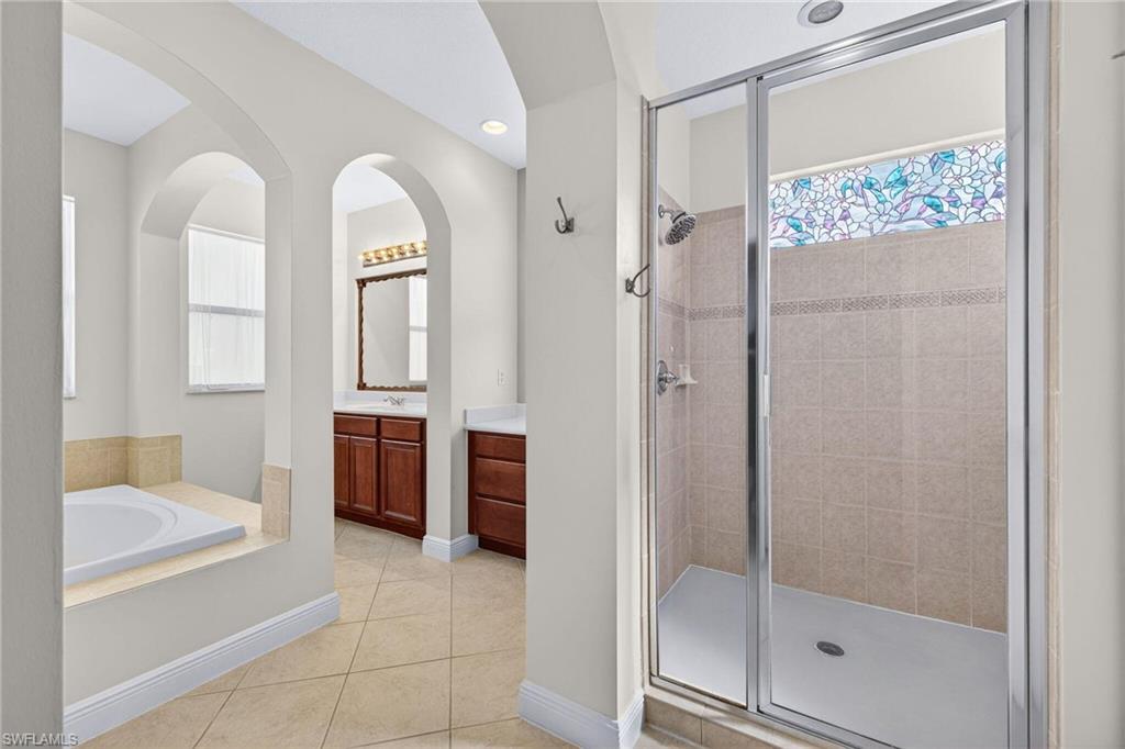 2212 Vardin Place Naples, FL 34120 - Photo 18 of 50 a spacious bathroom with a glass shower door and a sink