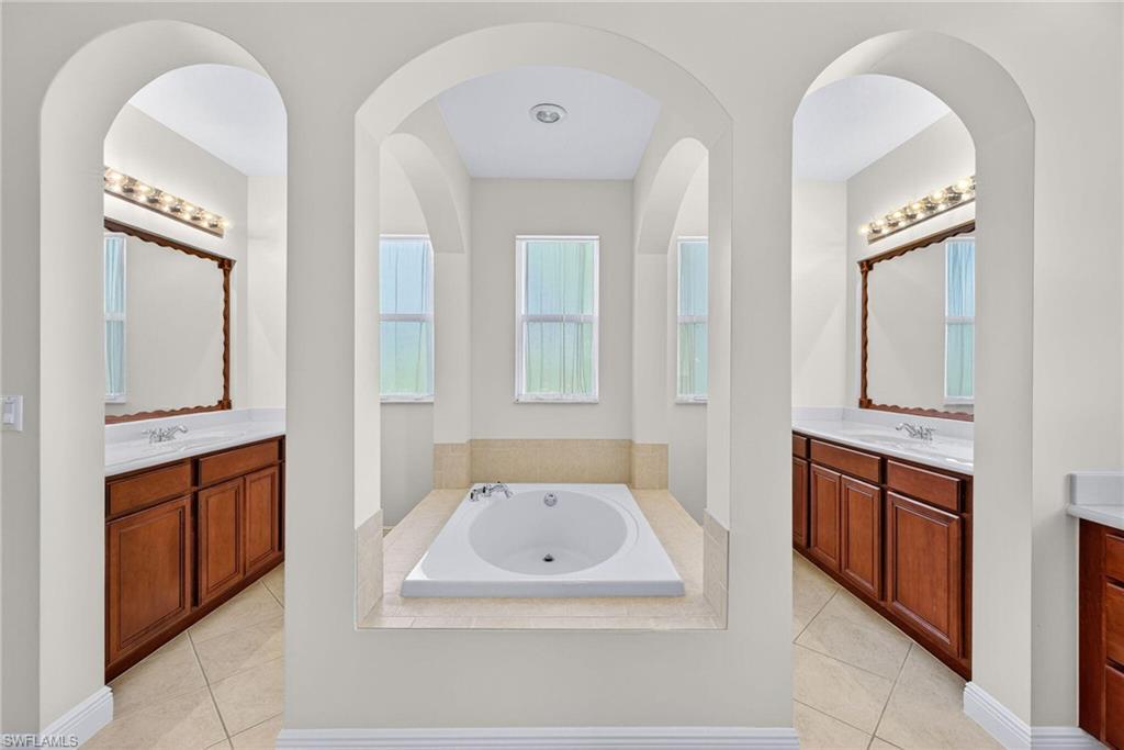 2212 Vardin Place Naples, FL 34120 - Photo 19 of 50 a bathroom with 2 sink tub and a mirror