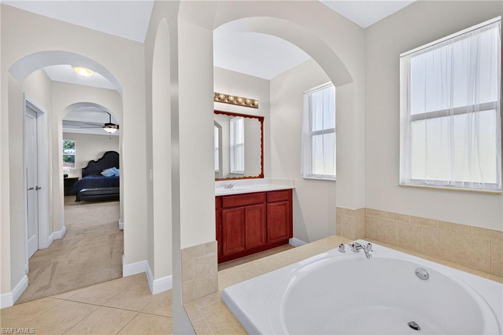 2212 Vardin Place Naples, FL 34120 - Photo 20 of 50 a en suite bathroom with a tub sink and mirror