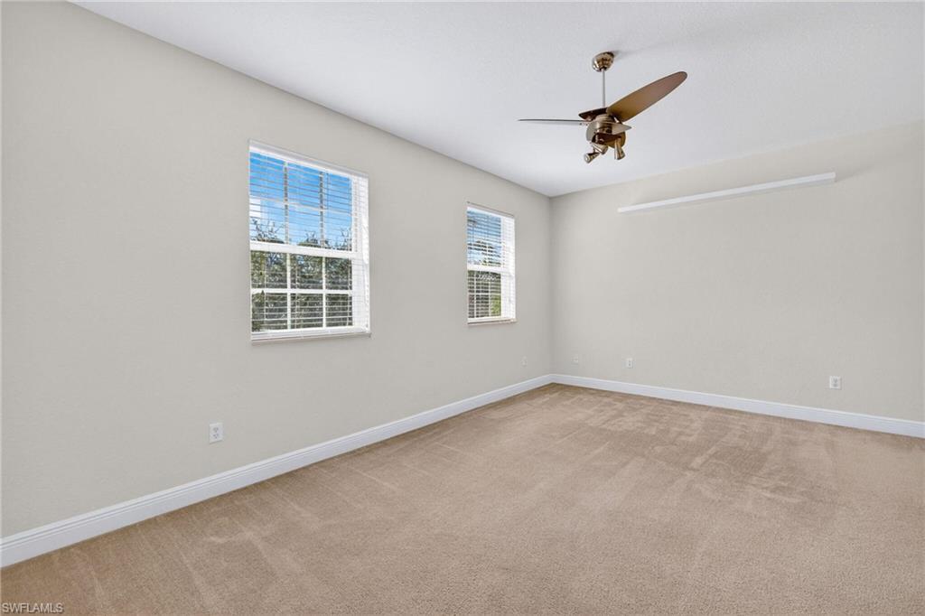 2212 Vardin Place Naples, FL 34120 - Photo 22 of 50 an empty room with windows and ceiling fan