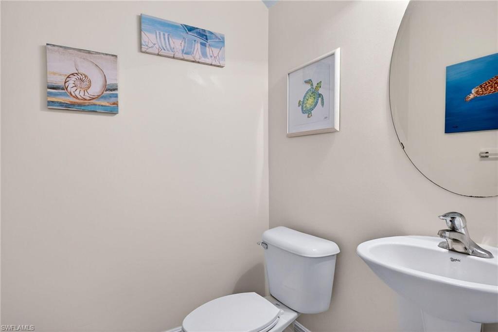 2212 Vardin Place Naples, FL 34120 - Photo 28 of 50 a white toilet sitting next to a bathroom sink