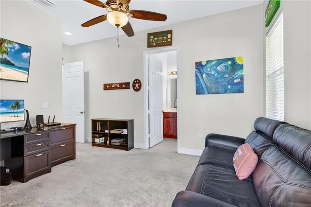 a living room with furniture a flat screen tv and a window
