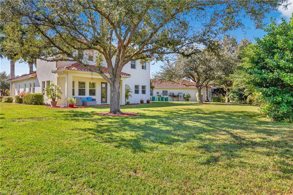 2212 Vardin Place Naples, FL 34120 - Photo 40 of 50 a view of a house with a big yard and large trees