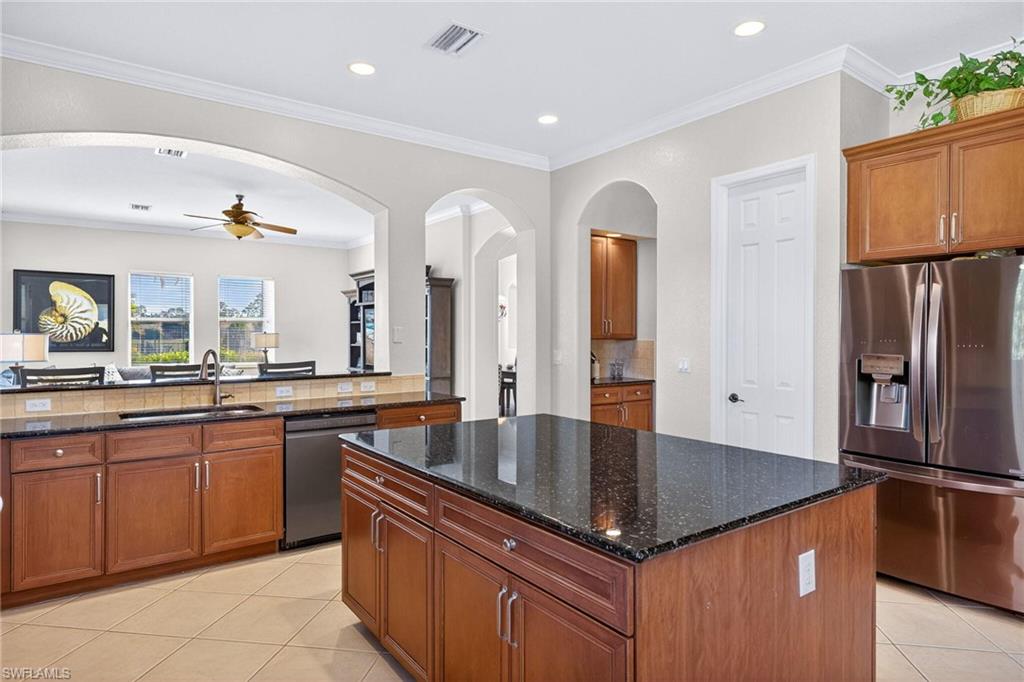2212 Vardin Place Naples, FL 34120 - Photo 9 of 50 a kitchen with stainless steel appliances granite countertop a sink and a refrigerator