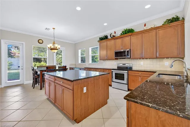 a kitchen with stainless steel appliances granite countertop a stove a sink and a microwave