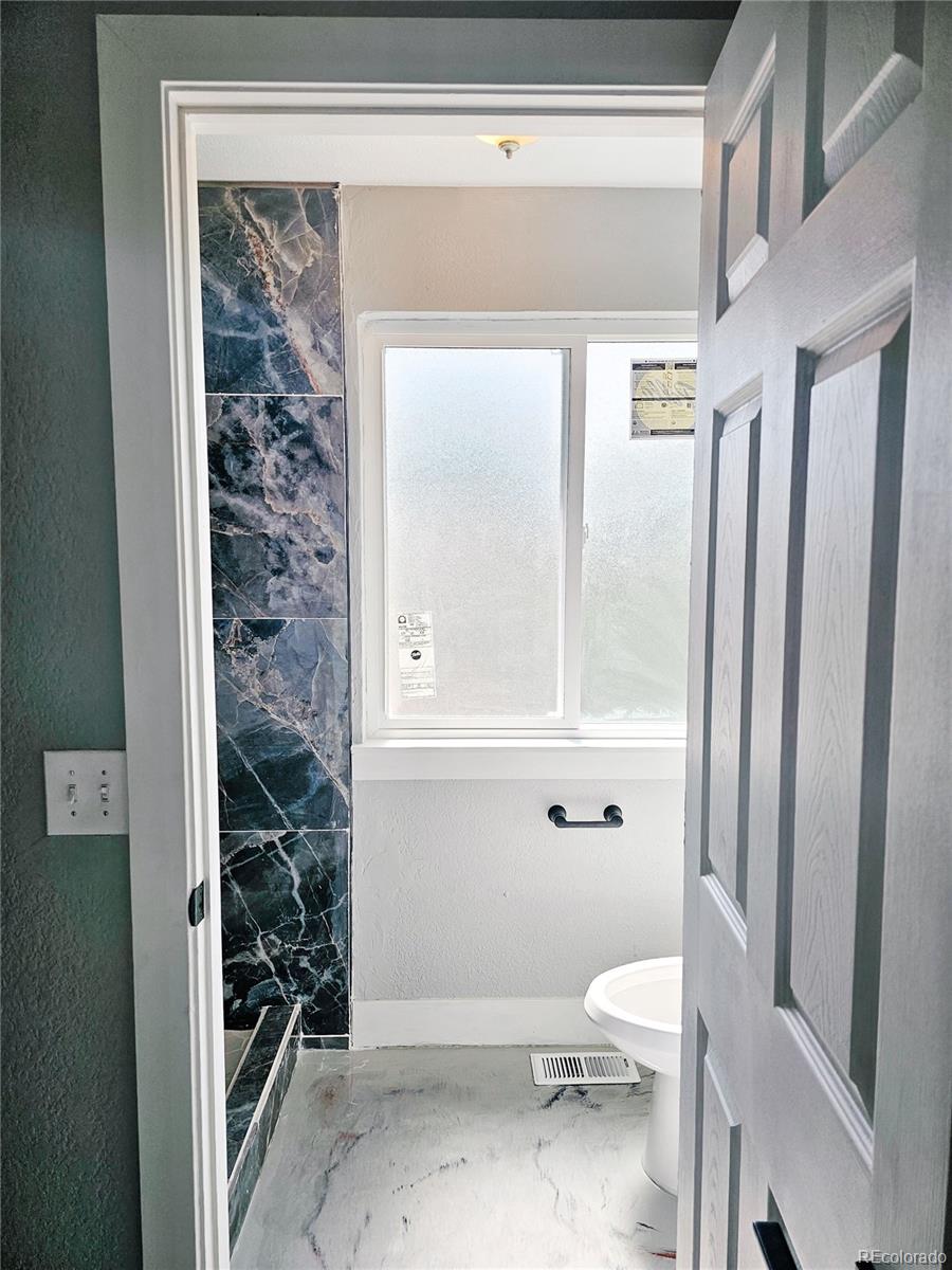 4716 Freeport Way Denver, CO 80239 - Photo 13 of 29 a bathroom with a toilet and a shower