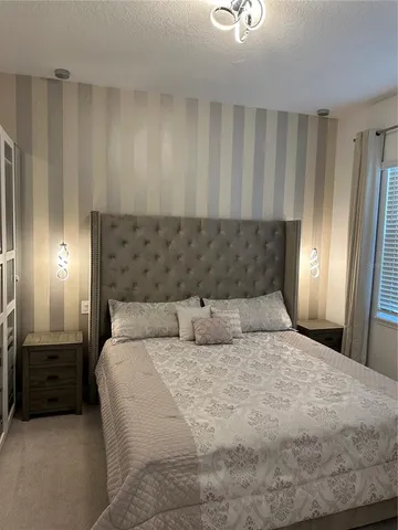 a large bed sitting in a room next to a lamp