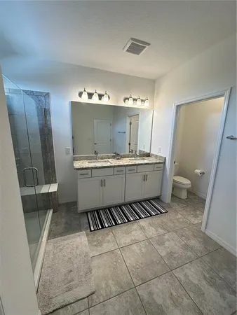 a room with a sink a toilet and a mirror