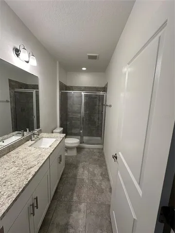 a bathroom with a granite countertop sink a mirror and a bathtub