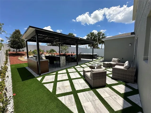 a living room with patio furniture and a potted plants