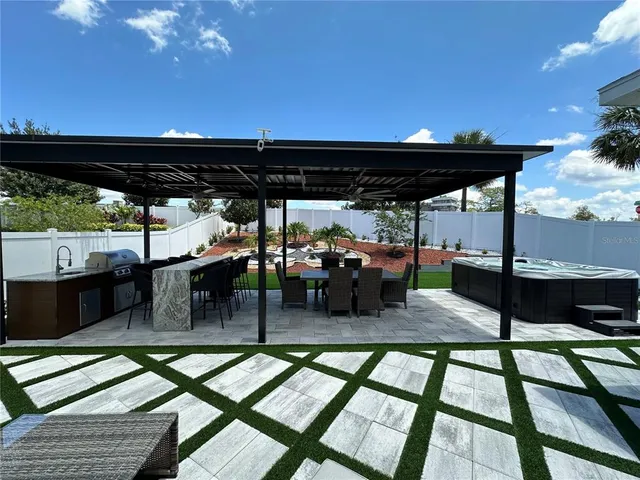 a view of a house with backyard sitting area and swimming pool