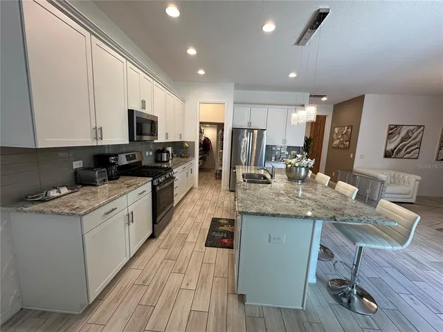 a kitchen with stainless steel appliances granite countertop a sink stove and cabinets