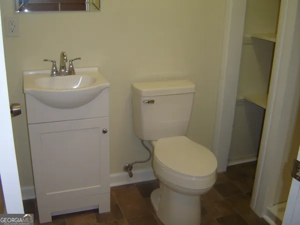 a bathroom with a sink toilet and a mirror