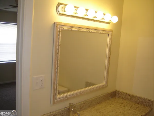 a bathroom with a granite countertop sink and vanity