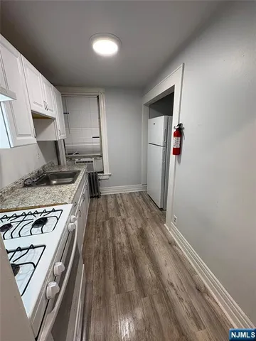 a kitchen with a stove and wooden floor