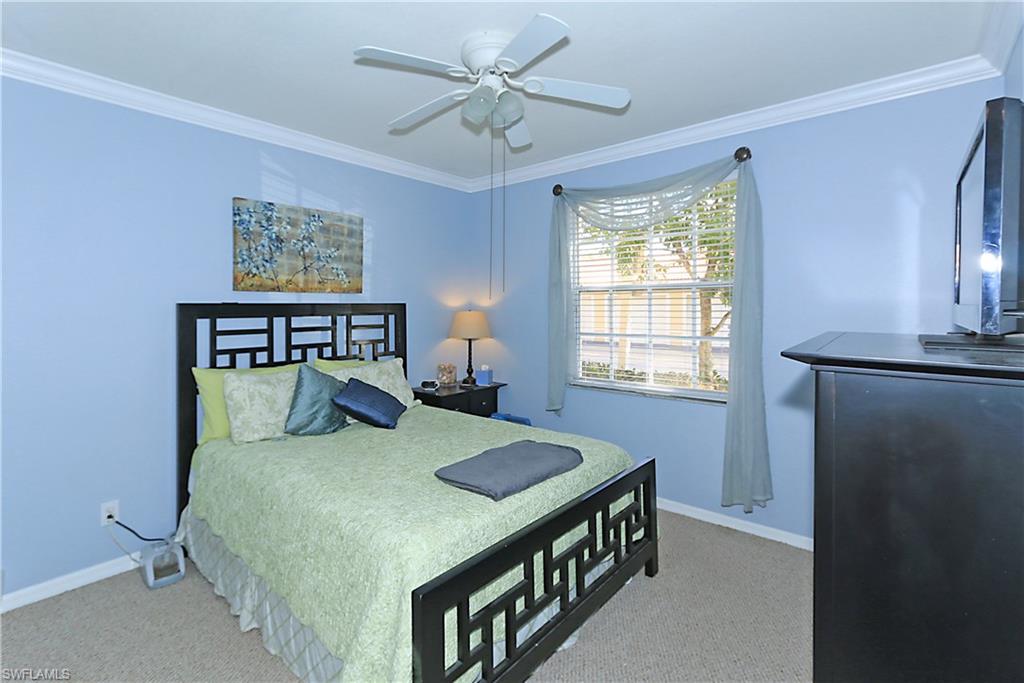 4670 St Croix Lane, Unit 618 Naples, FL 34109 - Photo 11 of 19 a bedroom with a bed a window and a chandelier
