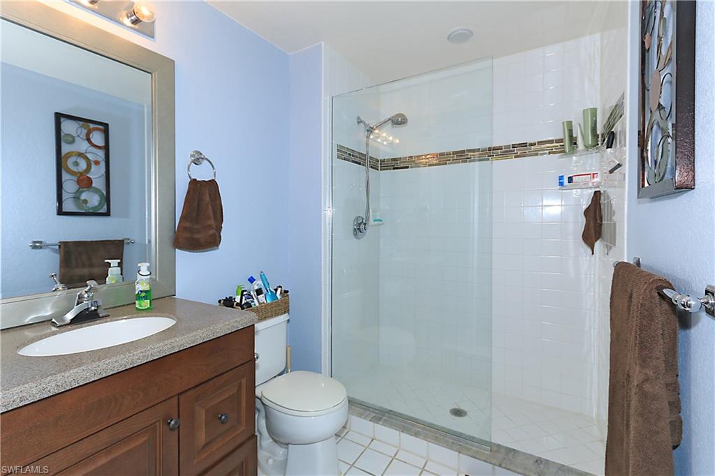 4670 St Croix Lane, Unit 618 Naples, FL 34109 - Photo 12 of 19 a bathroom with a granite countertop sink toilet and shower