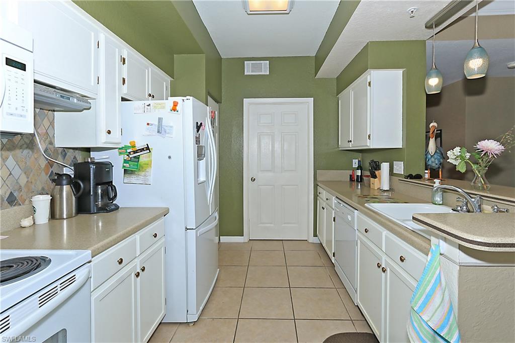 4670 St Croix Lane, Unit 618 Naples, FL 34109 - Photo 5 of 19 a kitchen with stainless steel appliances a refrigerator sink and cabinets