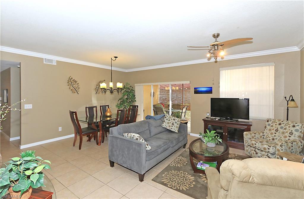 4670 St Croix Lane, Unit 618 Naples, FL 34109 - Photo 7 of 19 a living room with furniture a chandelier and a flat screen tv