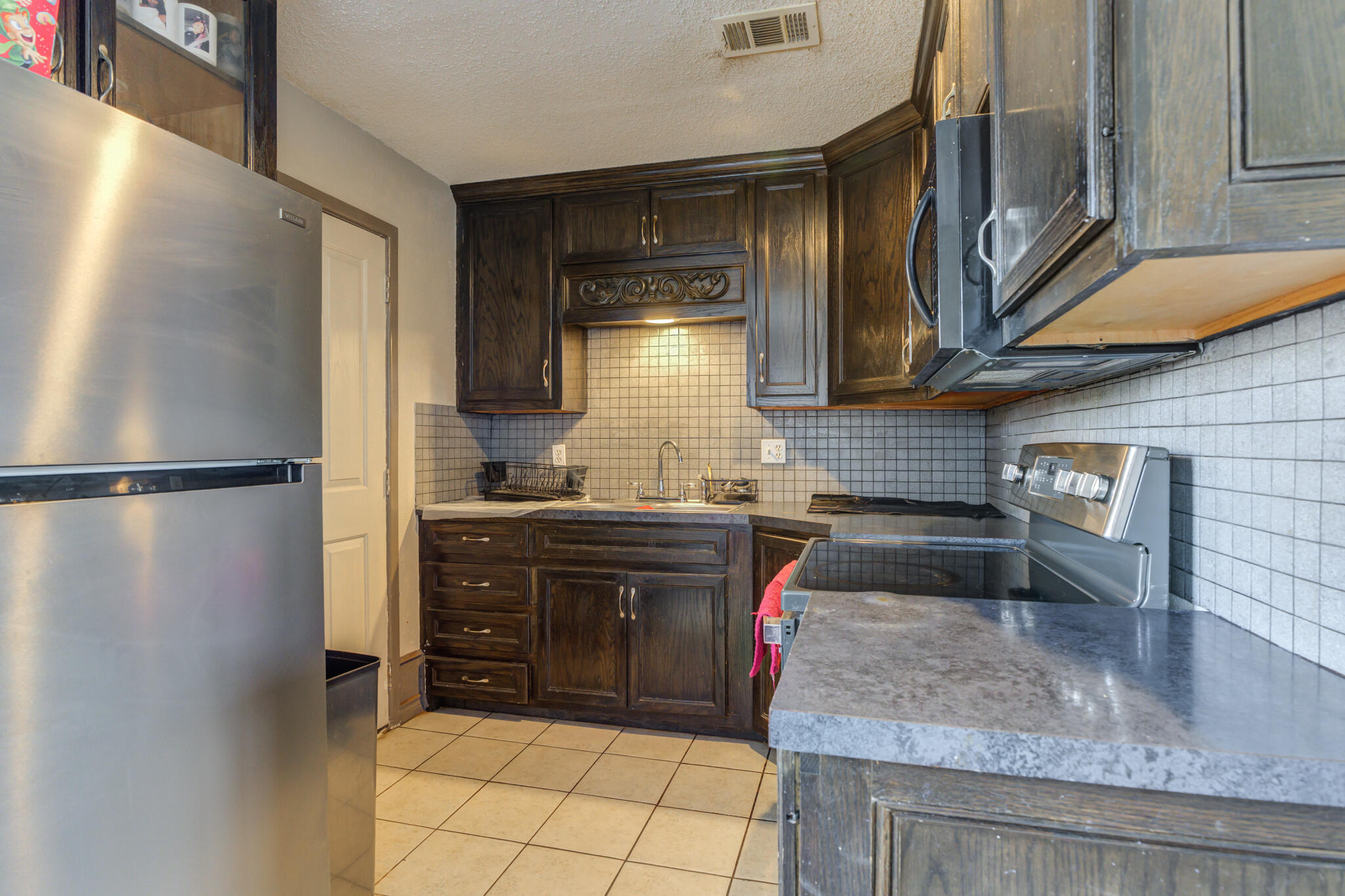 2901 Beech Avenue Lubbock, TX 79404 - Photo 12 of 26 a kitchen with granite countertop a refrigerator and a sink