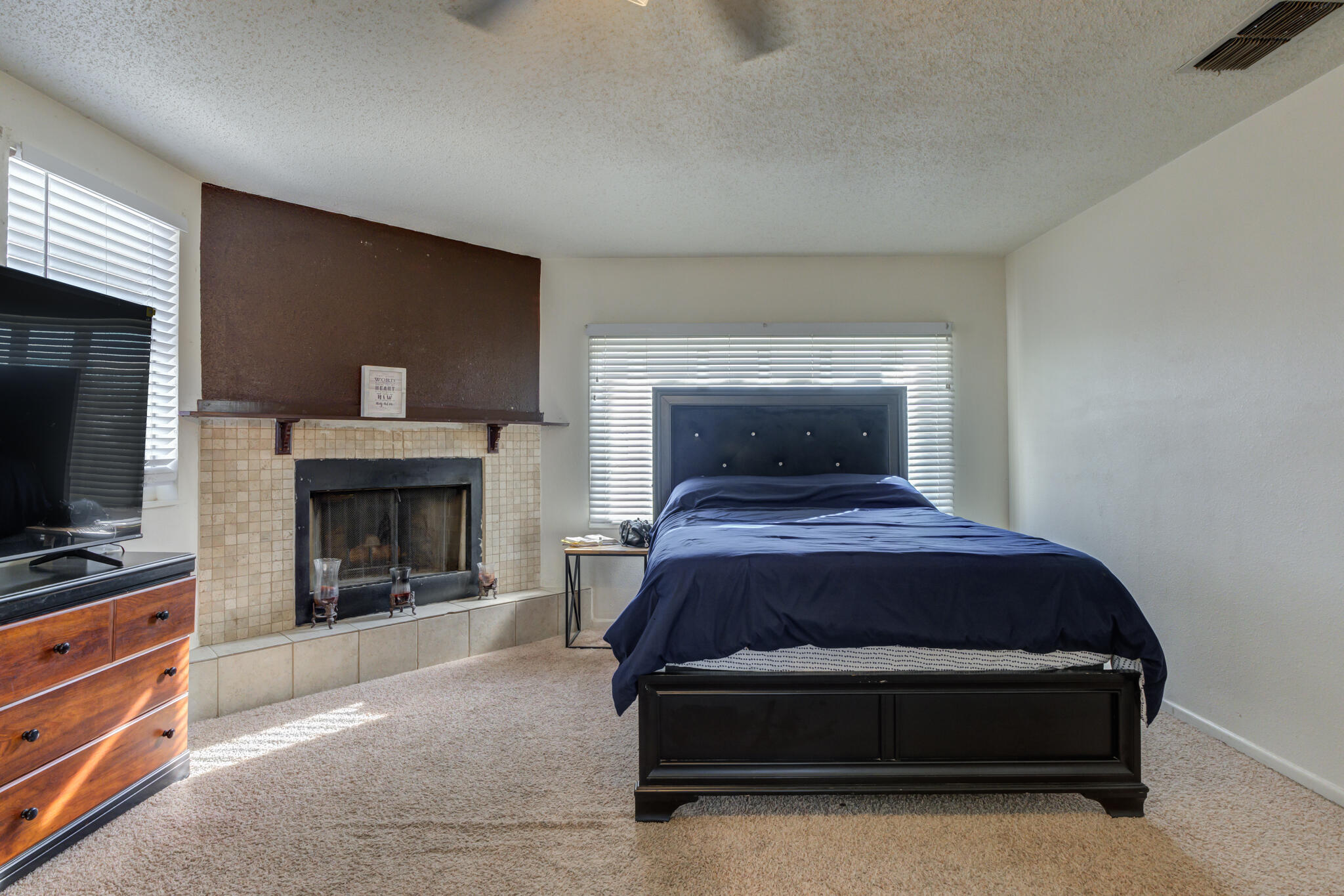 2901 Beech Avenue Lubbock, TX 79404 - Photo 16 of 26 a bedroom with a bed and a fireplace