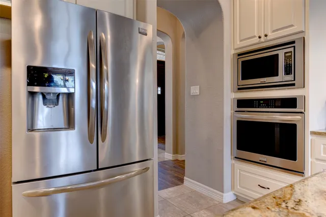 a metallic refrigerator freezer sitting in a kitchen
