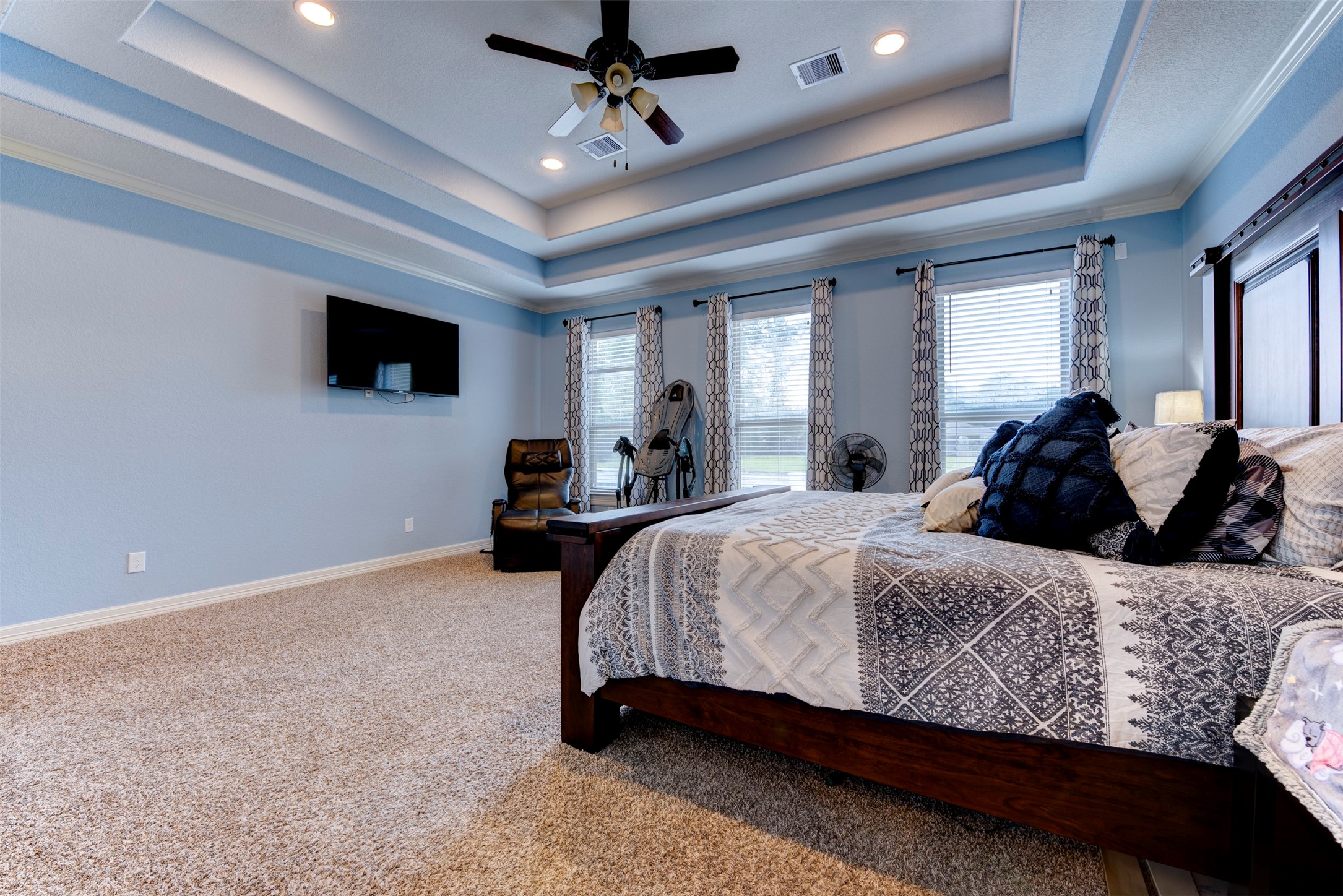 27635 Rio Blanco Drive Splendora, TX 77372 - Photo 26 of 46 a spacious bedroom with a bed a flat screen tv and a couch
