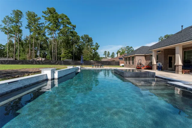 a swimming pool view with a seating space and a garden