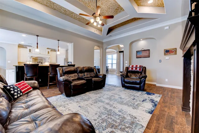 a living room with furniture chess board and a chandelier
