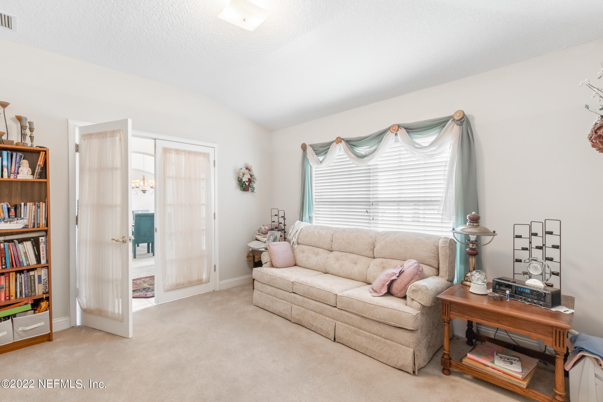 1304 Paradise Pond Road St. Augustine, FL 32092 - Photo 16 of 48 a living room with furniture a bookshelf and a window