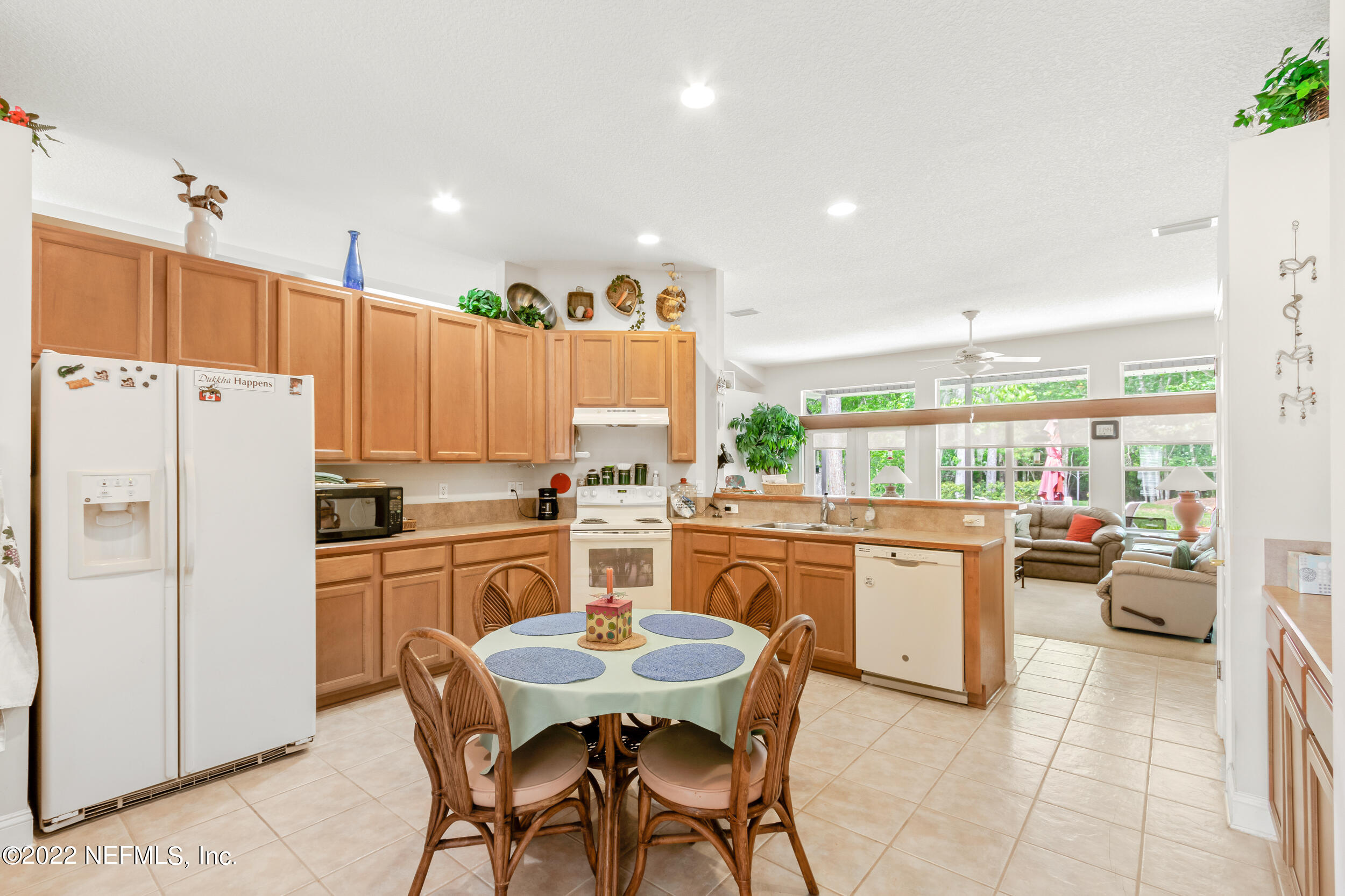1304 Paradise Pond Road St. Augustine, FL 32092 - Photo 22 of 48 a kitchen with stainless steel appliances granite countertop a refrigerator a kitchen island a stove a dining table and chairs with the wooden floor