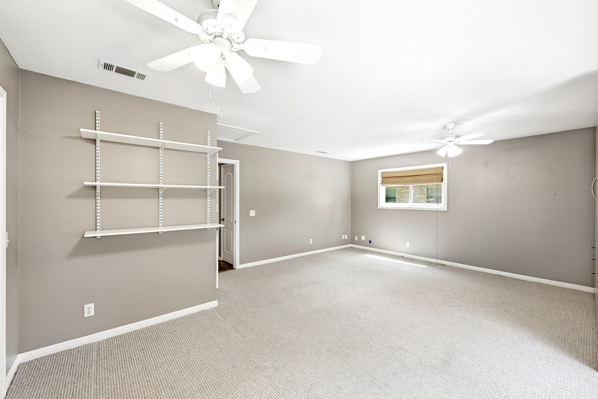 8608 Crest Ridge Circle Austin, TX 78750 - Photo 26 of 38 A spacious room offers comfortable carpeting and practical wall-mounted shelving.