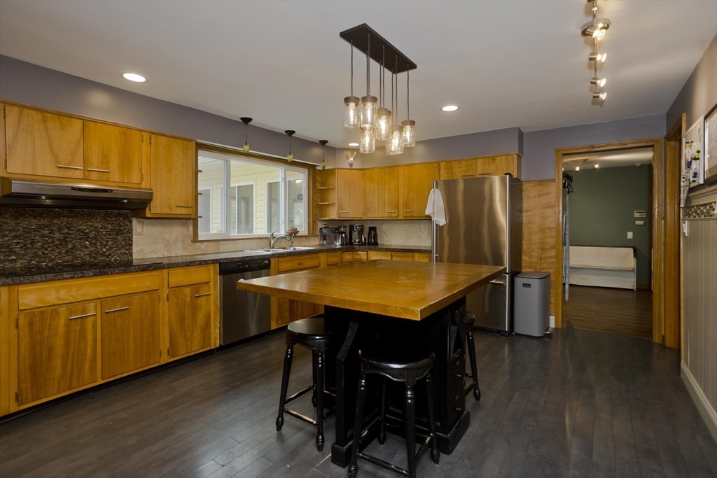 58 Longfellow Road Holyoke, MA 01040 - Photo 15 of 39 a kitchen with stainless steel appliances granite countertop dining table chairs sink and wooden floor