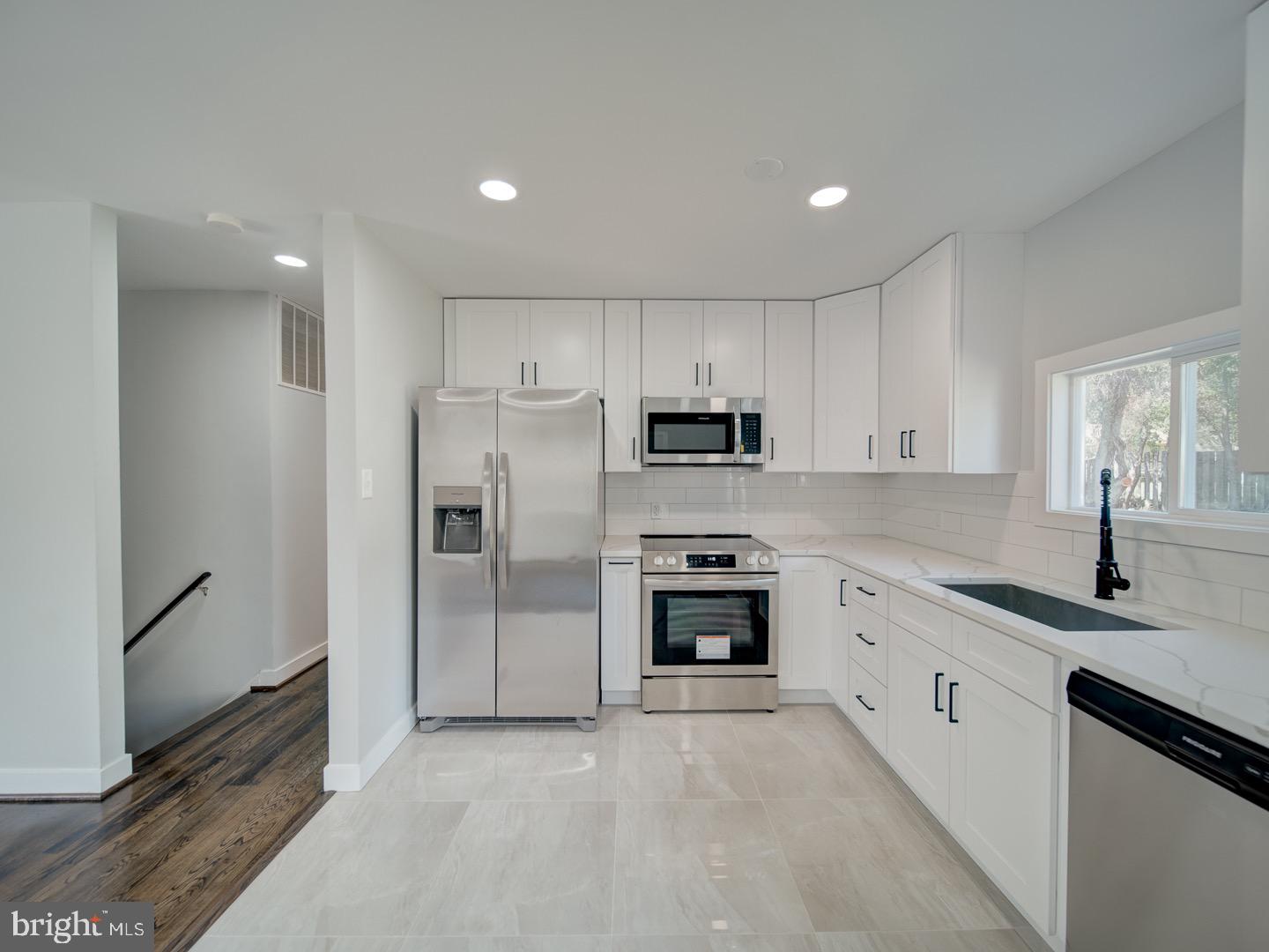 3812 Blackwater Road Clinton, MD 20735 - Photo 11 of 40 a kitchen with granite countertop a refrigerator stove top oven and sink