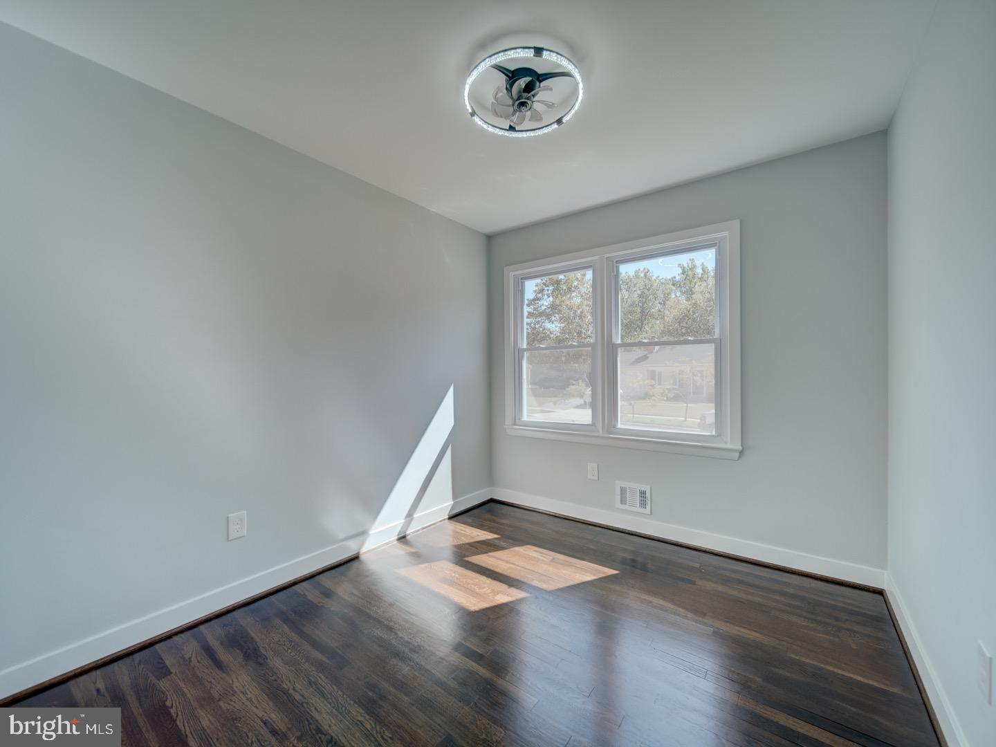 3812 Blackwater Road Clinton, MD 20735 - Photo 18 of 40 an empty room with wooden floor and windows