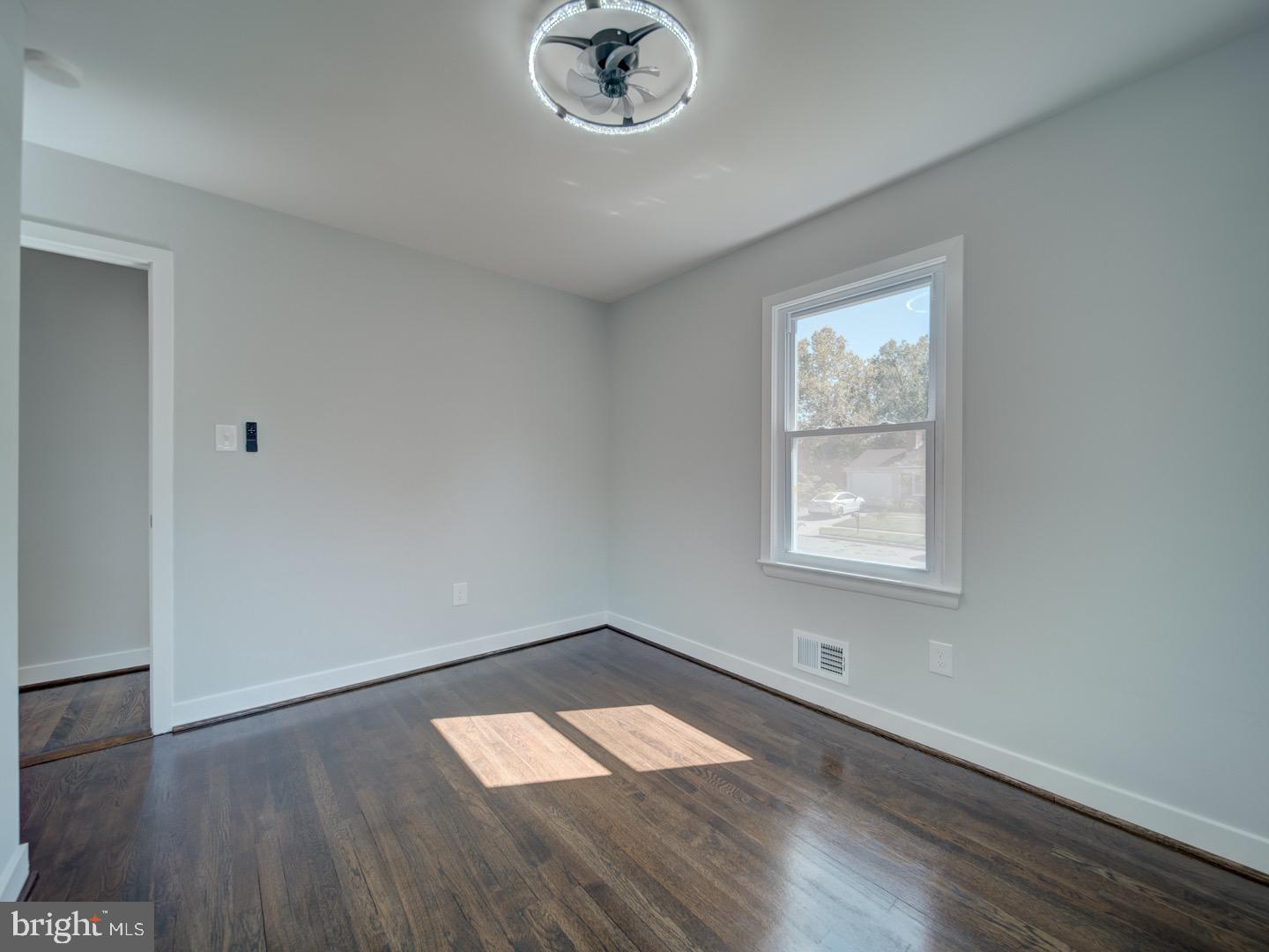 3812 Blackwater Road Clinton, MD 20735 - Photo 23 of 40 an empty room with wooden floor cabinet and windows