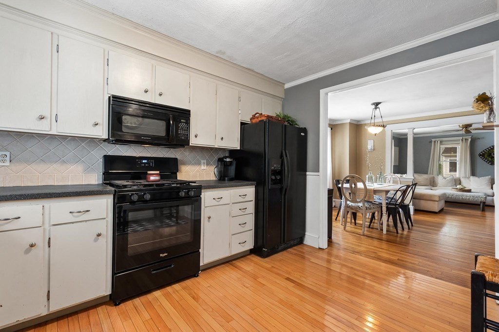 17 Columbia Road Danvers, MA 01923 - Photo 11 of 39 a kitchen with a refrigerator stove and dining table with wooden floor