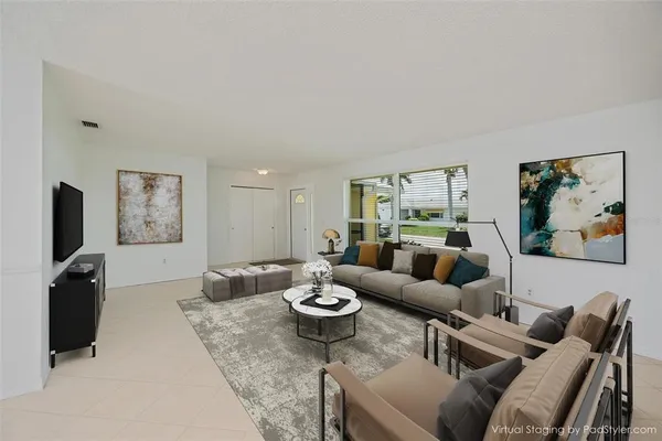 a living room with furniture a rug and wall painting