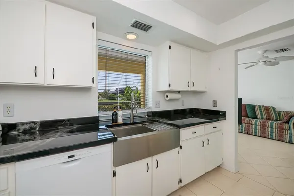 a kitchen with granite countertop a sink a stove and cabinets