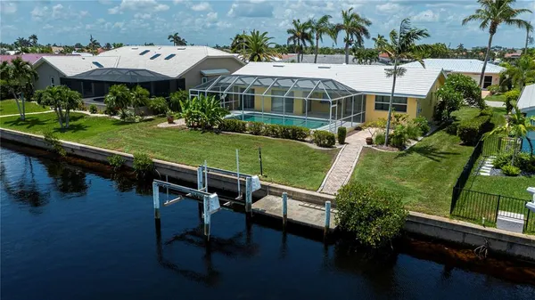 a view of a patio with table and chairs potted plants and large trees