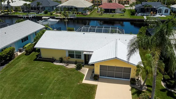 a view of a white house with a yard and sitting area