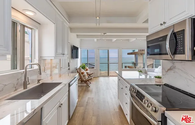 a kitchen with stainless steel appliances a sink stove and wooden cabinets